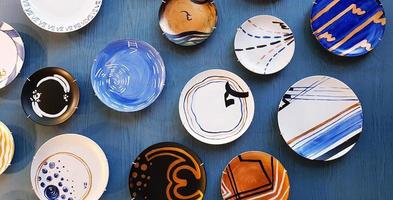 groupe coloré de plat ou assiette décorer sur fond de mur en bois bleu. concept de vaisselle, déco, design et objet d'art photo
