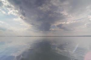 nuages sombres sur la surface de l'eau lisse photo de paysage