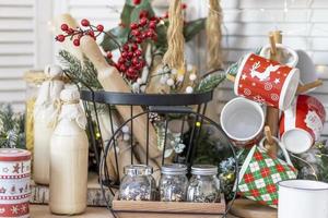 table dans la cuisine avec des bouteilles de lait, des tasses et des décorations de Noël