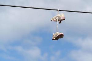 chaussures de sport accrochées à un câble métallique photo