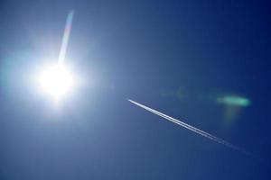 les pistes d'avion suivent les chemtrails dans le ciel bleu profond photo