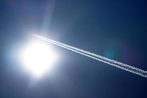 les pistes d'avion suivent les chemtrails dans le ciel bleu profond photo