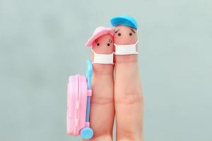 art des doigts de famille heureuse avec masque facial. homme et femme partant en vacances. photo