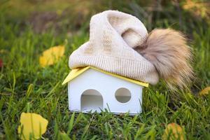 un bonnet de laine est posé sur le toit de la maison. le concept de chauffage alternatif. photo