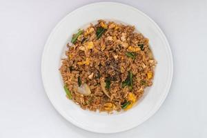 riz frit simple avec des ingrédients simples, riz, œuf au plat, oignon, carotte et légumes. riz frit sur la plaque blanche isolée sur fond blanc. cuisine simple de style asiatique.