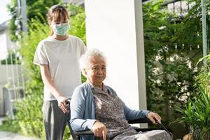 soignant aide et soins asiatique senior ou âgée vieille dame patiente assise sur un fauteuil roulant jusqu'à la rampe dans l'hôpital de soins infirmiers, concept médical fort et sain. photo