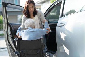 Une patiente asiatique âgée ou âgée, assise sur un fauteuil roulant, se prépare à aller à sa voiture, concept médical solide et sain. photo