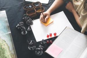 Femme écrivant à la main pour créer une histoire de configuration aventure jeu de rôle sur table et jeux de société passe-temps photo