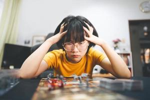 jeune adulte sud-est asiatique femme jouant au jeu de société sur la table supérieure photo