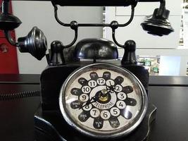 une photo de téléphone fixe noir vintage avec horloge
