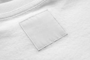 étiquette de vêtements de soin de lessive blanche vierge sur fond de texture de tissu photo