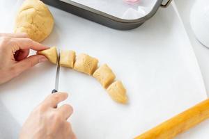 le processus de fabrication de biscuits avec des formes en forme de fleurs, un rouleau à pâtisserie et un plateau, le concept de cuisine, de cuisson à la maison. photo