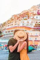 vacances d'été en italie. jeune couple dans le village de positano en arrière-plan, côte amalfitaine, italie photo