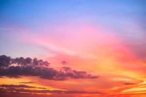 beau dégradé orange et arc-en-ciel nuages de couleur et lumière du soleil sur le ciel bleu parfait pour l'arrière-plan, prendre en soirée, crépuscule photo