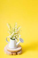 printemps, fête des mères ou 8 mars composition de nature morte avec bouquet de muguet dans un arrosoir décoratif photo