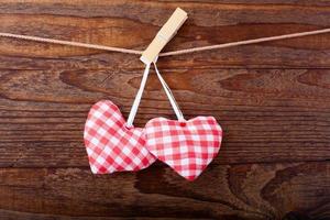 feuille vierge, une note, une feuille de papier déchirée et des coeurs rouges vintage suspendus à une guirlande. concept de la saint valentin photo