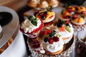 restauration de mariage de luxe, table avec desserts modernes, cupcakes, bonbons aux fruits. délicieuse barre chocolatée lors d'une réception de mariage coûteuse. célébration de vacances de fête. mise au point sélective photo