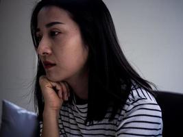 malheureuse femme asiatique fille déçue, triste à cause d'un problème à la maison seule, se sentir seule, stressée, souffrant d'une mauvaise relation, rompre, divorcer, femme confuse, dépression santé mentale, solitude photo