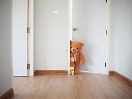 à l'intérieur de la maison. la famille des ours en peluche ouvrit la porte derrière le mur et y jeta un coup d'œil. photo