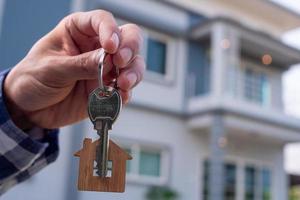 le propriétaire déverrouille la clé de la maison pour une nouvelle maison photo