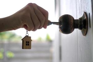 le propriétaire déverrouille la clé de la maison pour une nouvelle maison photo