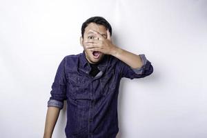 drôle d'homme asiatique furtivement évident en chemise bleue isolé sur fond blanc. photo