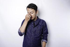 un portrait d'un homme asiatique portant une chemise bleue isolé sur fond blanc a l'air déprimé photo