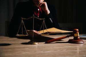 concept de justice et de droit. juge masculin dans une salle d'audience avec le marteau, travaillant avec, clavier d'ordinateur et d'accueil, lunettes, sur table à la lumière du matin photo