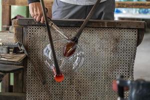 maître verrier tout en travaillant dans l'usine de verre de four de murano venise italie photo