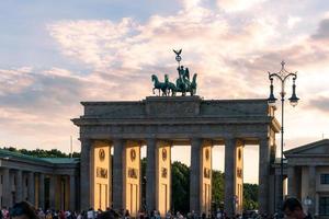 berlin, allemagne-8 août 2022-des gens et des touristes se promènent sur la pariser platz devant la porte de brandebourg pendant un coucher de soleil photo