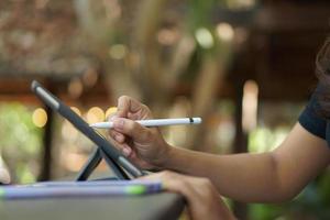 main féminine travaillant en regardant le plan sur ordinateur au café photo