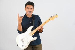 portrait de jeune homme asiatique en chemise bleue avec guitare électronique isolé sur fond blanc photo