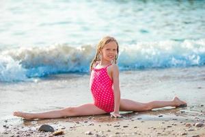 petite fille active à la plage s'amusant beaucoup au bord de la mer photo