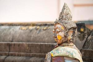 statue traditionnelle en pierre vintage en personnage de femme à l'arrière du wat phra that chom kitti, un lieu de culte à chiang rai, thaïlande. photo