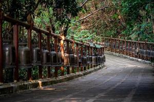 passerelle avec les cloches de bronze en métal autour et à côté de celle-ci dans l'environnement de la jungle, au temple wat phra that doi tung, province de chiang rai, au nord de la thaïlande. photo