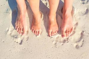 gros plan mère et enfant pieds sur la plage de sable blanc photo