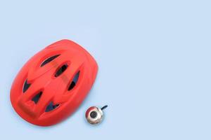 casque de vélo rouge et cloche de vélo sur fond bleu avec espace de copie photo