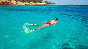 jeune homme plongée en apnée dans des eaux turquoises tropicales claires photo