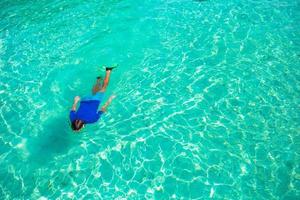 jeune homme plongée en apnée dans des eaux turquoises tropicales claires photo