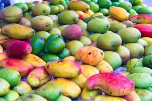 mangue fraîche, verte, rouge, jaune sur le marché local de l'île de mahe, seychelles photo