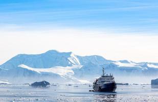 paquebot de croisière antarctique touristique dérivant dans le lagon parmi les icebergs avec glacier en arrière-plan, neco bay, antarctique photo