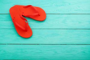 tongs rouges sur fond de bois bleu vue de dessus espace libre photo