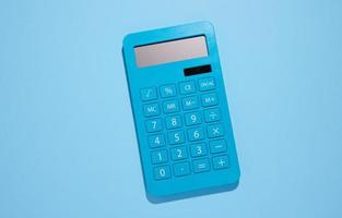 calculatrice en plastique bleu sur fond bleu, vue de dessus photo