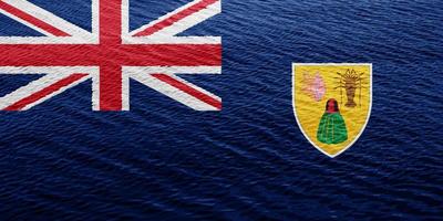 drapeau du territoire britannique d'outre-mer des îles turks et caicos sur un fond texturé. collage conceptuel. photo