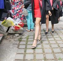 les étudiants diplômés de l'université font une séance photo dans le parc