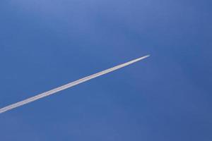 un avion et des traînées de vapeur dans le ciel photo