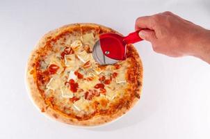 homme coupant une pizza photo