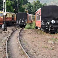 vue sur l'autocar de train jouet depuis le milieu de la voie ferrée pendant la journée près de la gare de kalka en inde, vue sur l'autocar de train jouet, jonction ferroviaire indienne, industrie lourde photo