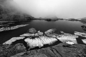 photo en noir et blanc de morceaux de glace dans un lac alpin