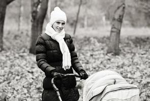 yang et belle mère avec poussette de bébé en plein air. photo